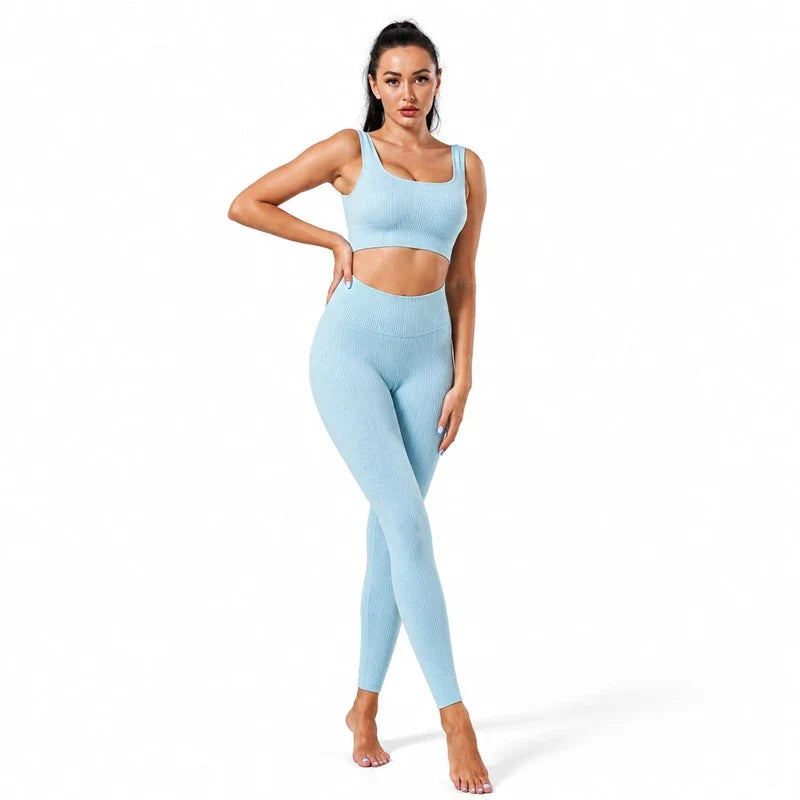 Woman wearing a light blue ribbed yoga crop top and matching high waist leggings.